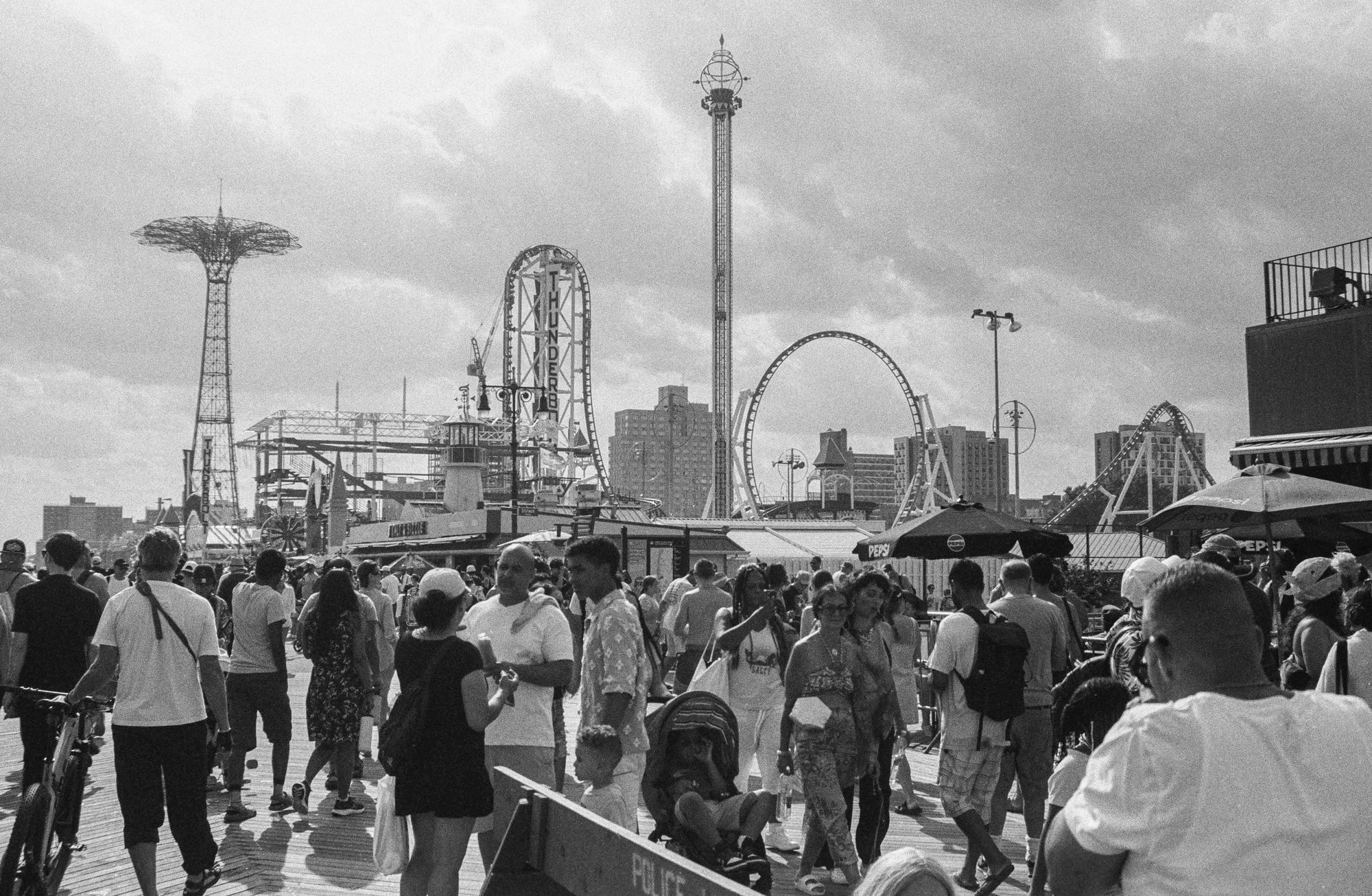 Color photograph of the Coney Island theme park skyline in summer — Parachute Jump tower, Cyclone roller coaster, Ferris wheel, Brooklyn NYC.