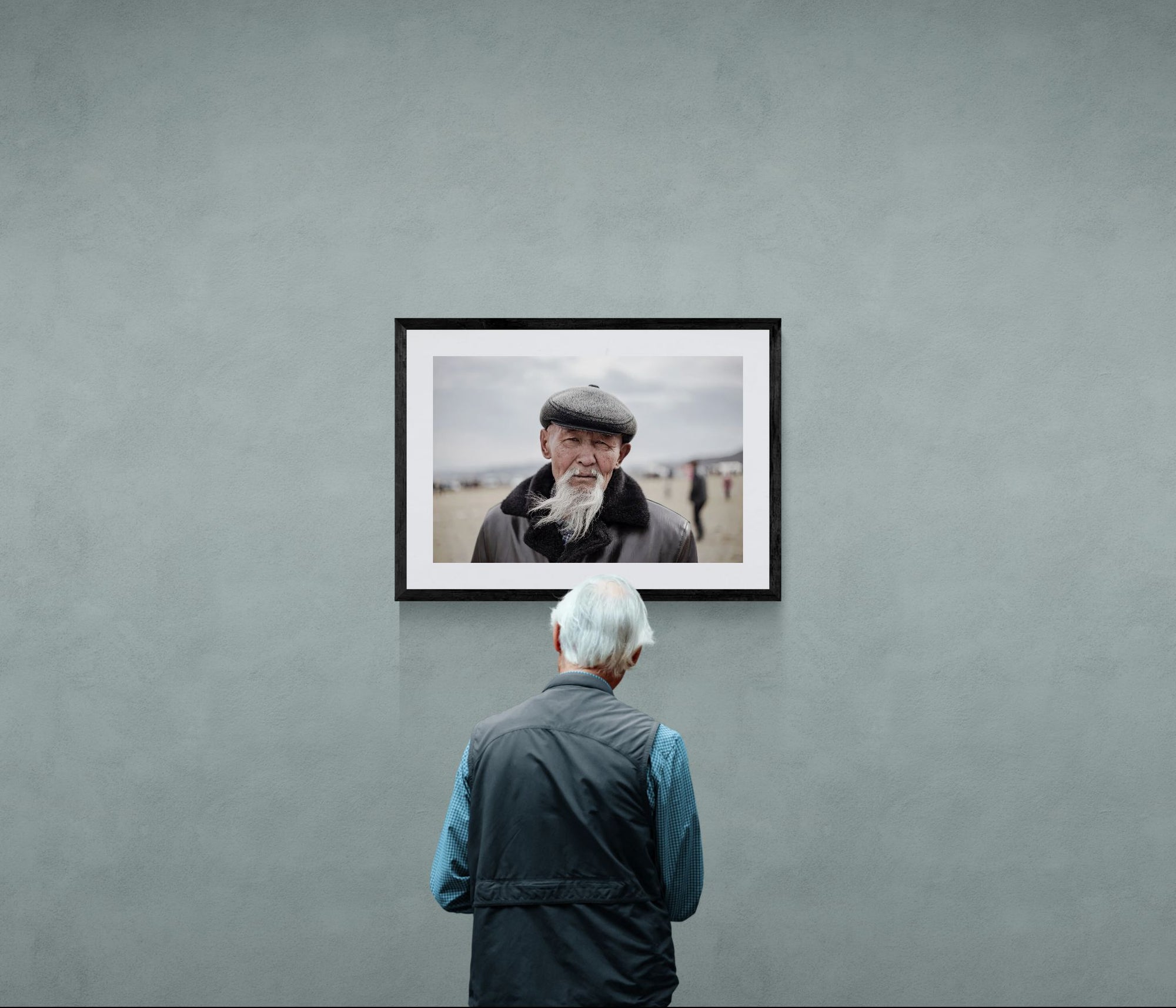 Old Mongolian Man Portrait, Bayan-Ölgii framed in black above a beige sofa, sunlit yellow plaster wall — Good Beans NYC.