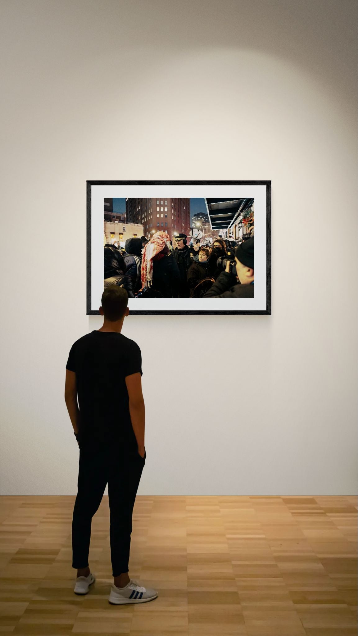 NYC NYPD Megaphone Standoff, Pro Palestine framed in black on a gallery wall with a viewer in a straw hat in front — Good Beans NYC.