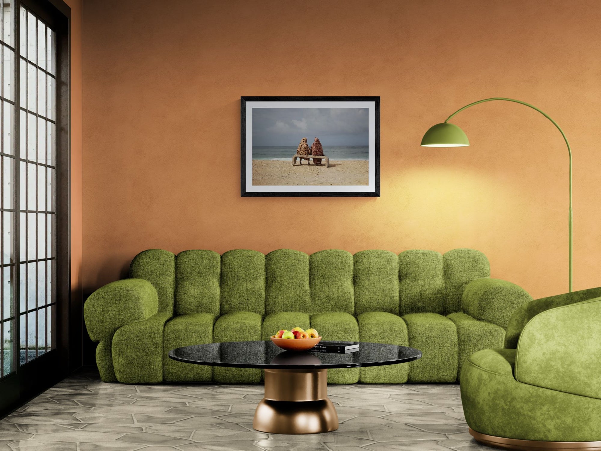 Moroccan Women on Bench by the Sea, Taghazout framed in black above a terracotta velvet sofa, gray plaster wall — Good Beans NYC.