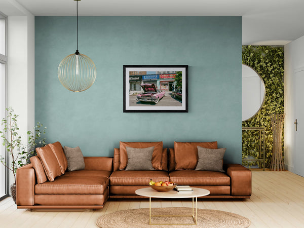 NYC Pink Caddy at Coney Island, Chabad-Christ-Pizza Block framed in black above a terracotta velvet sofa, gray plaster wall — Good Beans NYC.
