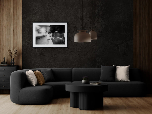 NYC Subway Wall Street Platform Blur framed in black above a beige sofa, sunlit yellow plaster wall — Good Beans NYC.