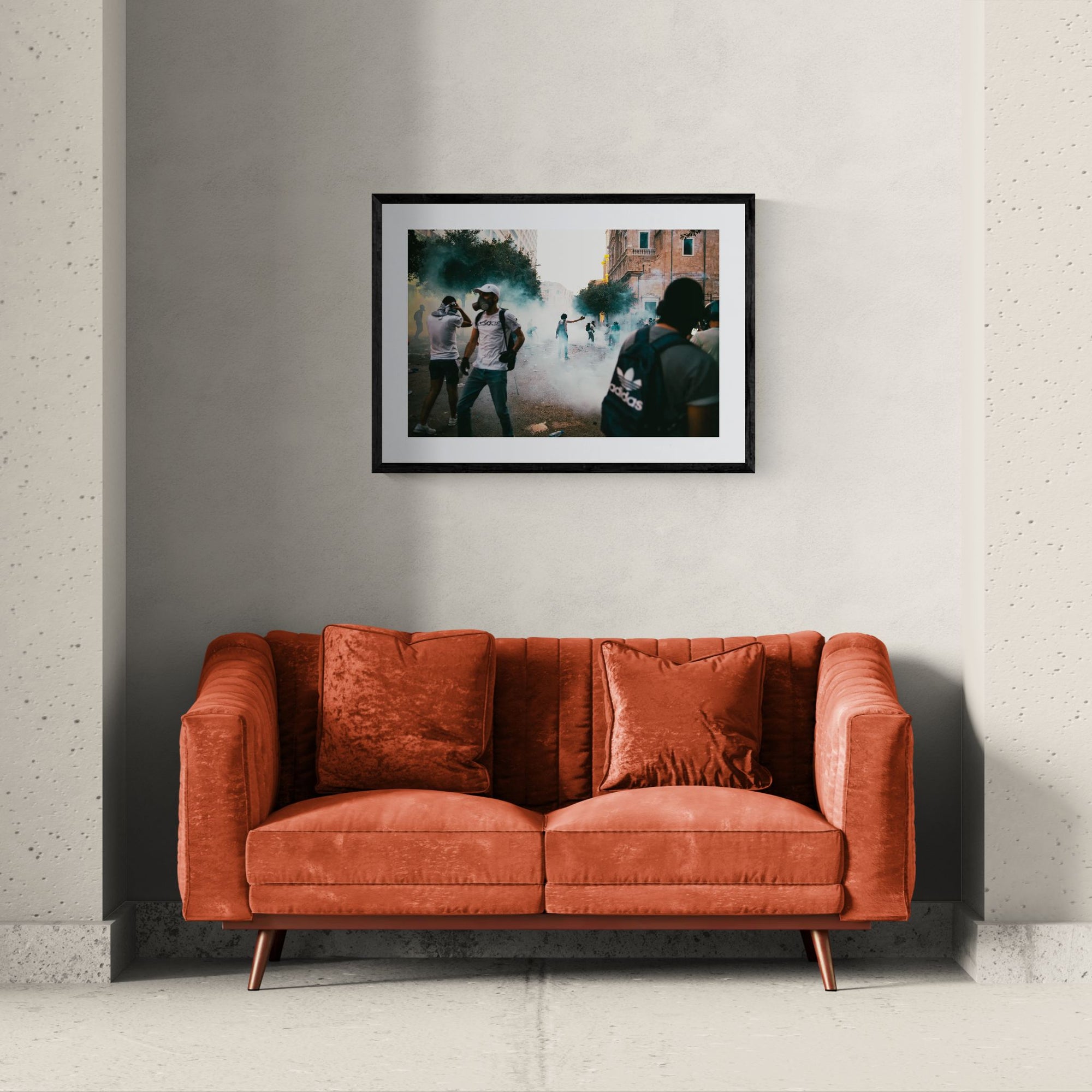 Beirut Tear Gas Protest, October Revolution framed in black above a beige sofa, sunlit yellow plaster wall — Good Beans NYC.