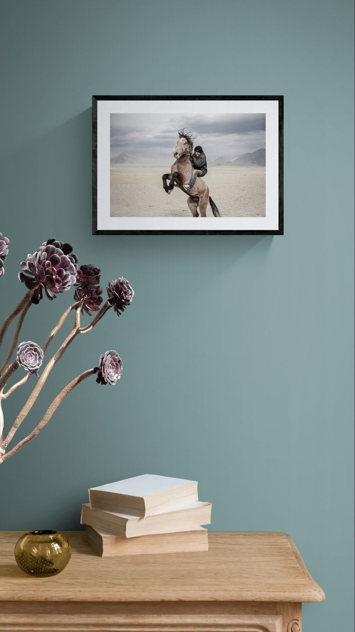 Mongolian Horse Rider, Bayan-Ölgii framed in black above a brown leather sectional, teal wall, gold pendant lamp — Good Beans NYC.