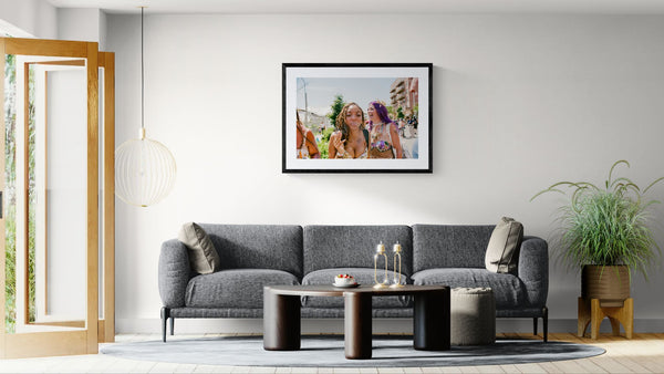 NYC Mermaid Parade Smoking & Laughing, Coney Island framed in black above a terracotta velvet sofa, gray plaster wall — Good Beans NYC.