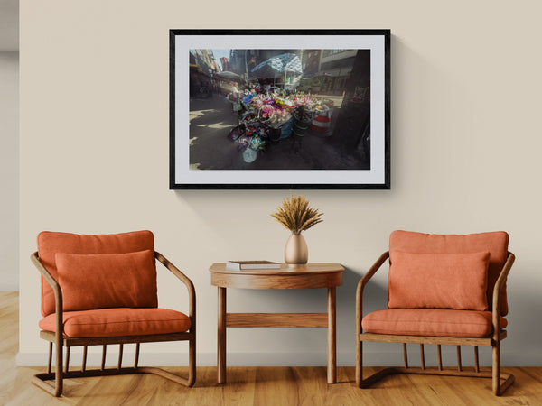 NYC Flower Cart Brooklyn — Under the J Train framed in black above a beige sofa, sunlit yellow plaster wall — Good Beans NYC.