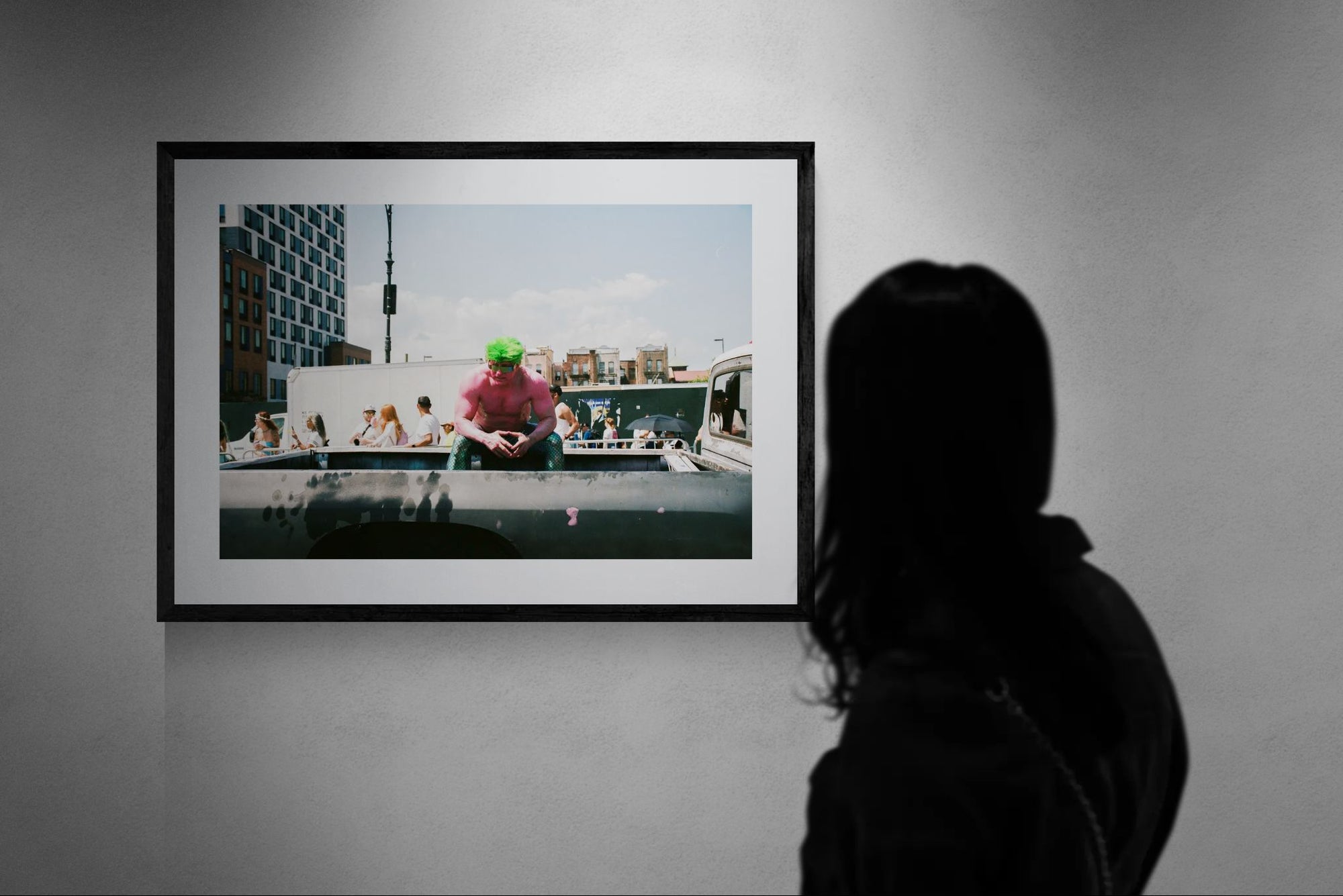 NYC Mermaid Parade Pink Hulk — Coney Island framed in black above a brown leather sectional, teal wall, gold pendant lamp — Good Beans NYC.