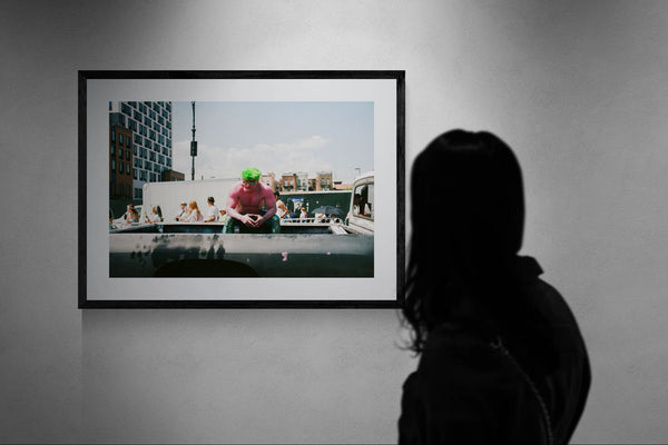 NYC Mermaid Parade Pink Hulk — Coney Island framed in black above a brown leather sectional, teal wall, gold pendant lamp — Good Beans NYC.