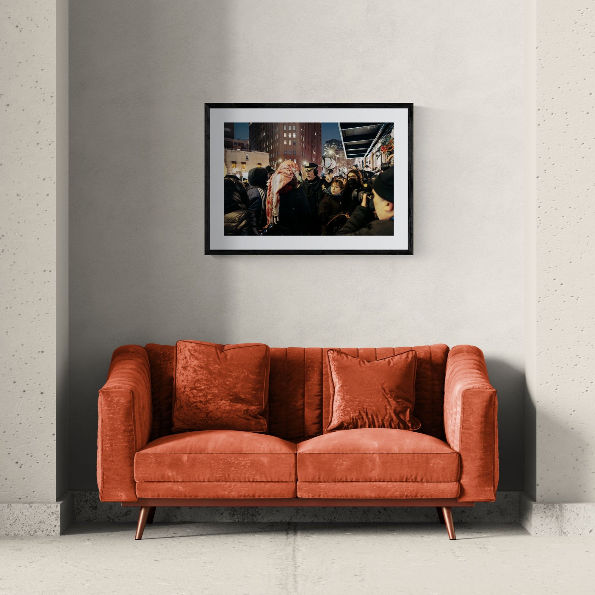 NYC NYPD Megaphone Standoff, Pro Palestine framed in black above a beige sofa, sunlit yellow plaster wall — Good Beans NYC.