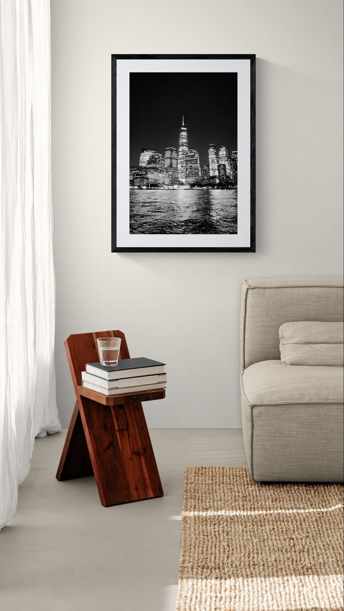 NYC Freedom Tower from the Hudson, Manhattan framed in black above a beige sofa, sunlit yellow plaster wall — Good Beans NYC.