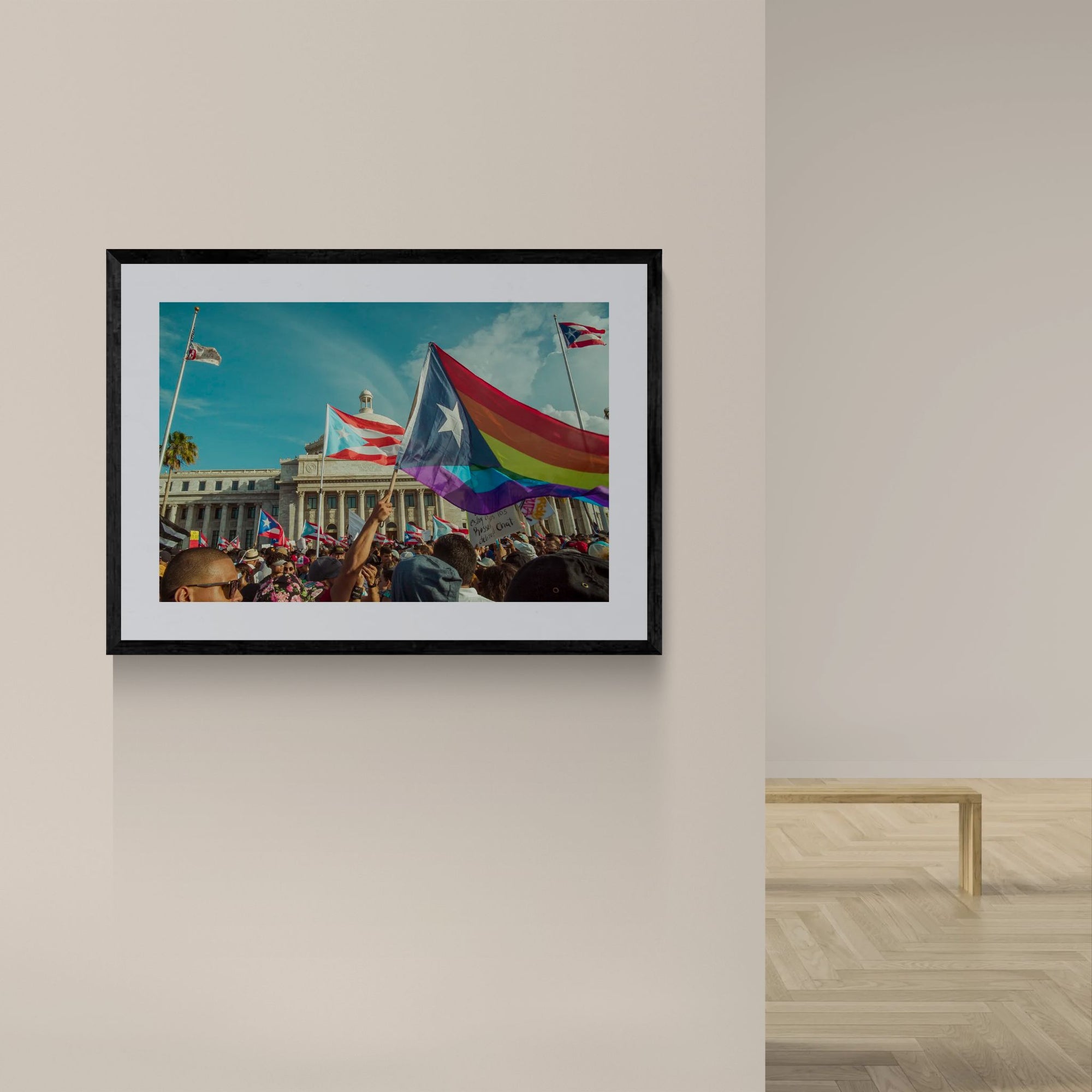Puerto Rico Capitol Pride Protest, Rainbow Flag framed in black on a gallery wall with a viewer in a straw hat in front — Good Beans NYC.