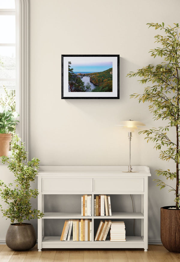 NY Mohonk Mountain House Fall, Hudson Valley framed in black above a brown leather sectional, teal wall, gold pendant lamp — Good Beans NYC.