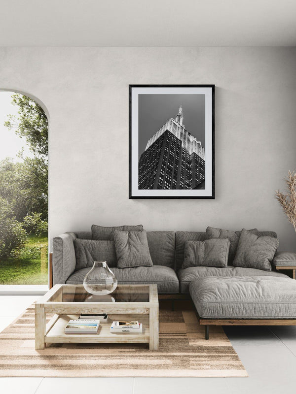 NYC Empire State Building, A Different Angle framed in black on a gallery wall with a side-profile viewer in a dark coat — Good Beans NYC.