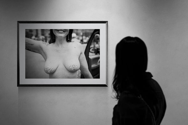 F*ck ICE Mermaid Protest Print — Coney Island framed in black on a gallery wall with a viewer in a straw hat in front — Good Beans NYC.