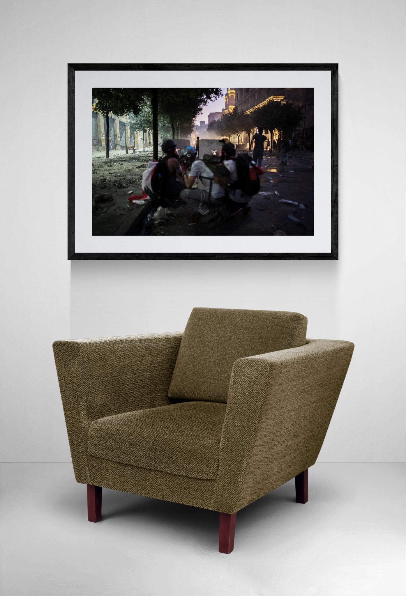 Beirut Shielded Protesters at Night framed in black above a beige sofa, sunlit yellow plaster wall — Good Beans NYC.