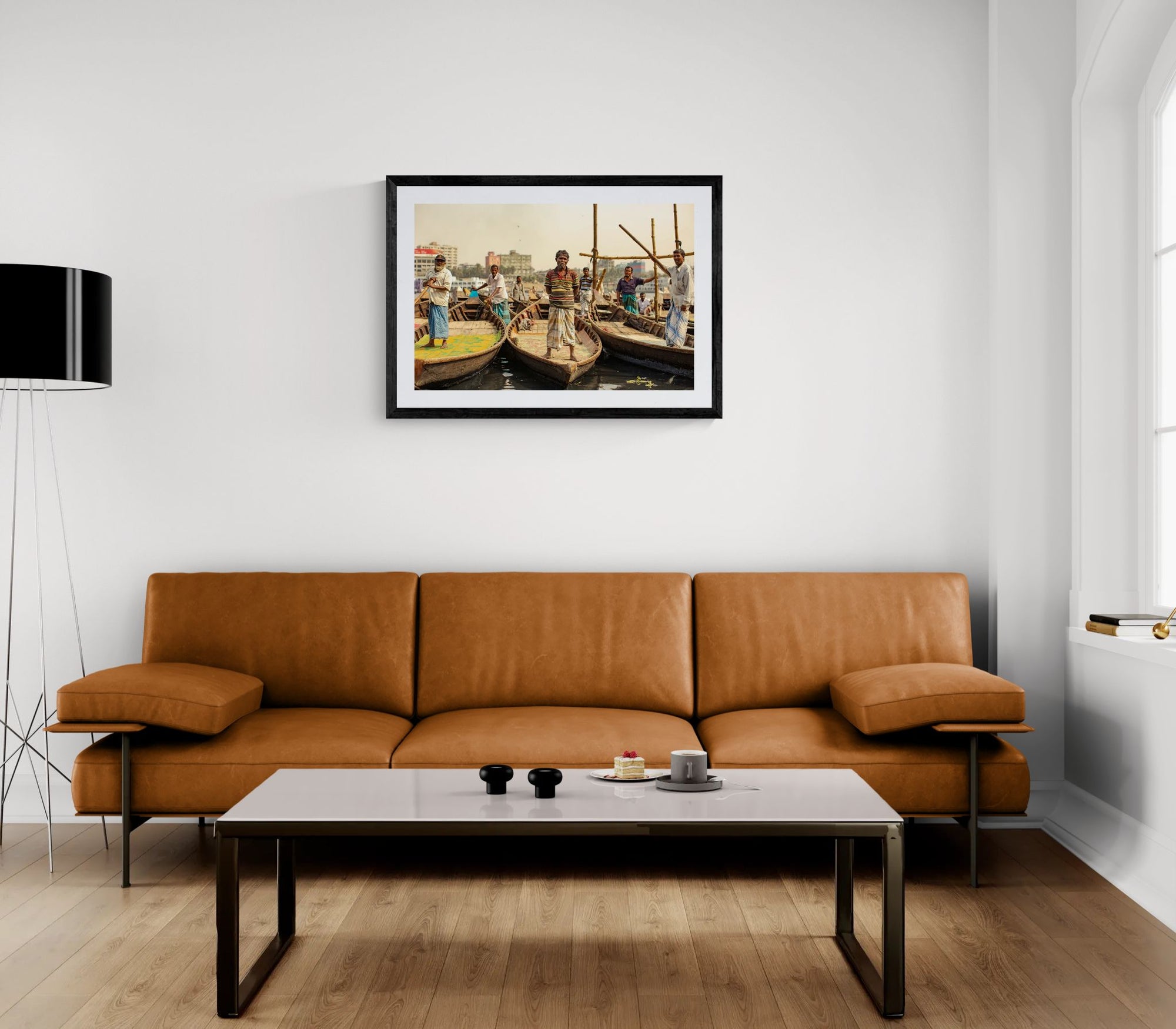 Dhaka Boat Men, Buriganga River framed in black above a beige sofa, sunlit yellow plaster wall — Good Beans NYC.