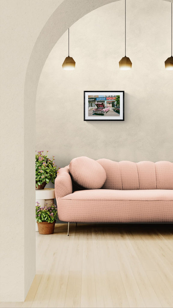 NYC Pink Caddy at Coney Island, Chabad-Christ-Pizza Block framed in black above a brown leather sectional, teal wall, gold pendant lamp — Good Beans NYC.