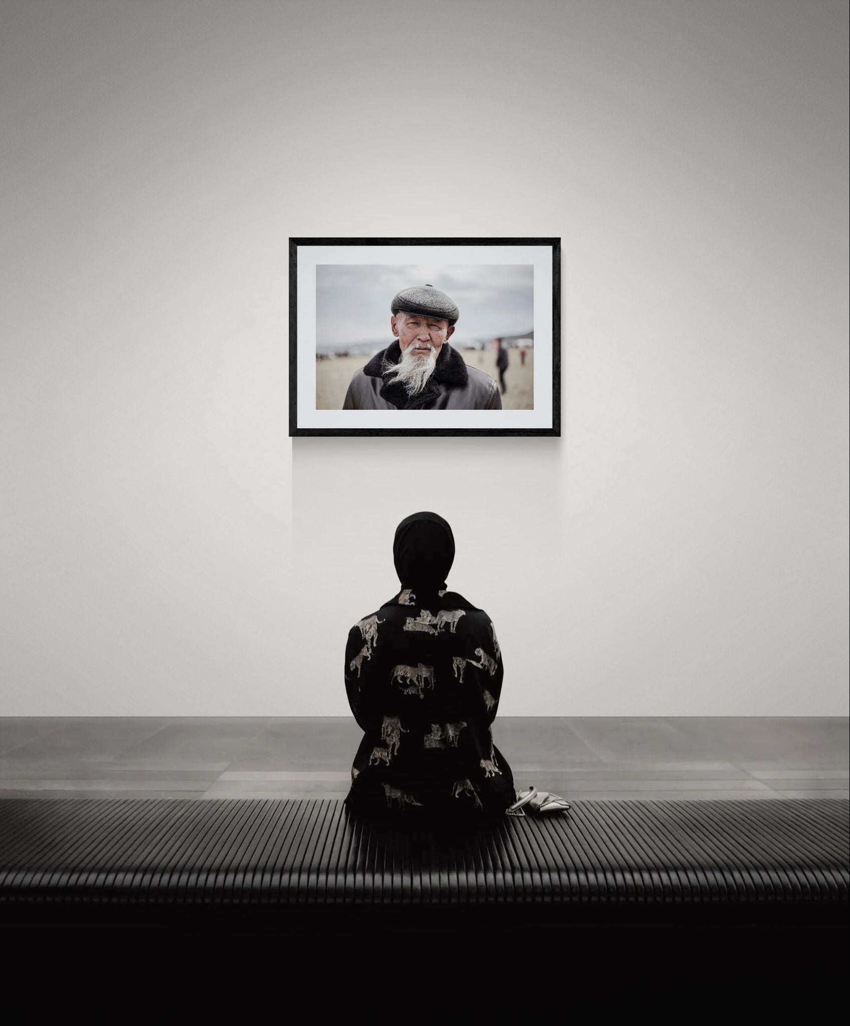 Old Mongolian Man Portrait, Bayan-Ölgii framed in black on a gallery wall with a side-profile viewer in a dark coat — Good Beans NYC.