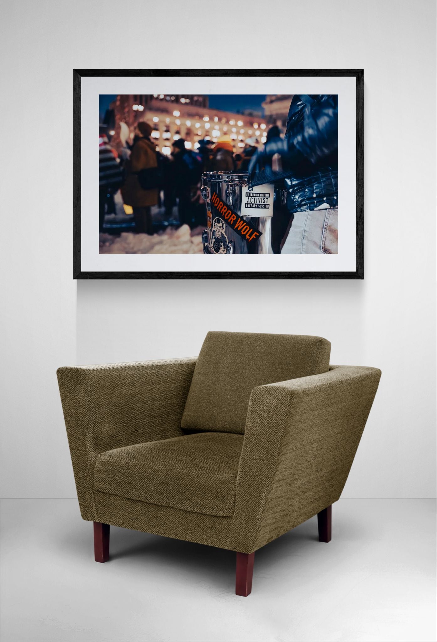 NYC Activist Therapy Session Drum, Winter Protest framed in black above a beige sofa, sunlit yellow plaster wall — Good Beans NYC.