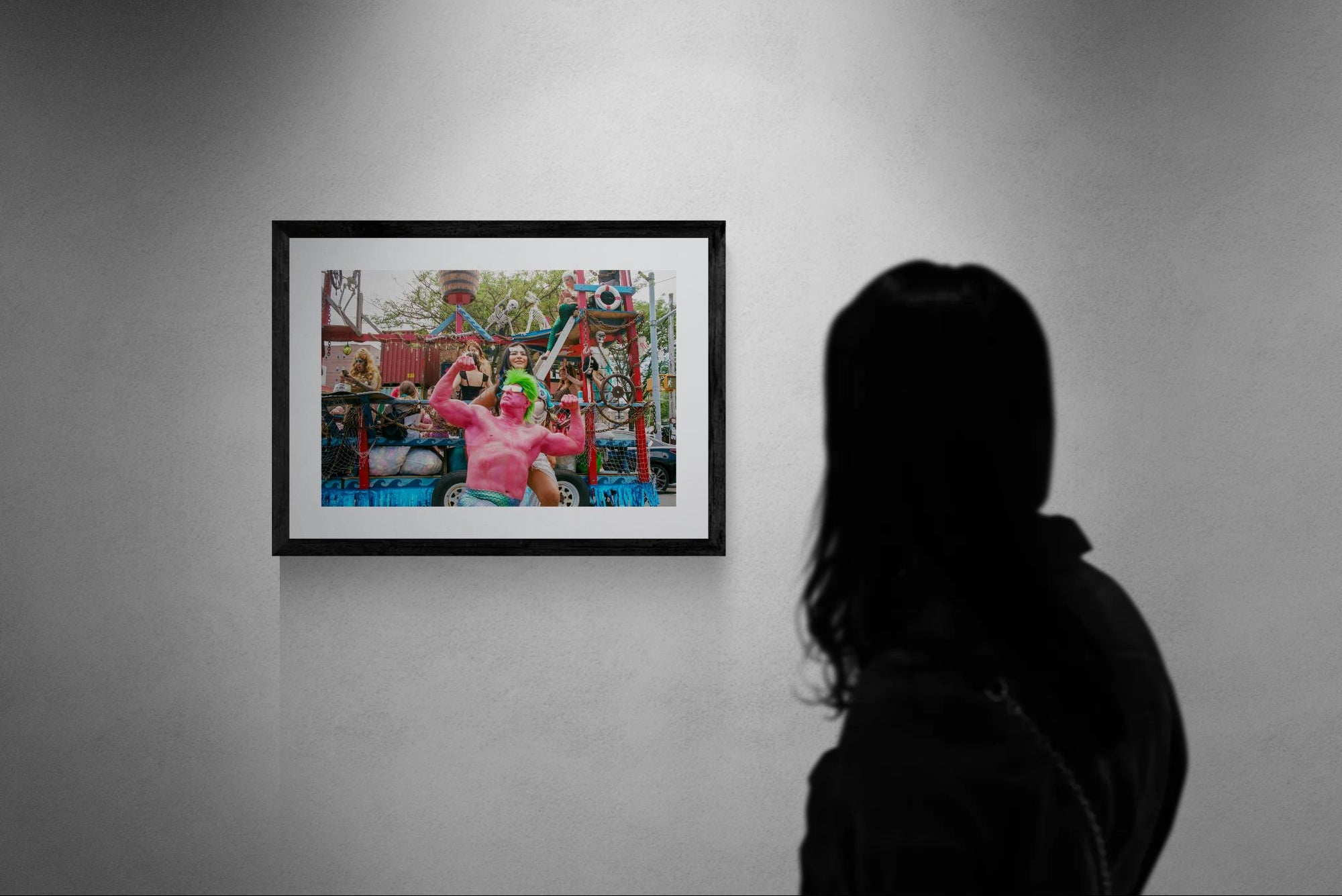 NYC Mermaid Parade Pink Hulk — Coney Island framed in black above a beige sofa, sunlit yellow plaster wall — Good Beans NYC.