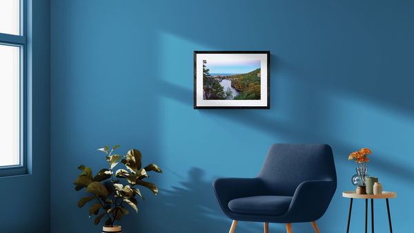 NY Mohonk Mountain House Fall, Hudson Valley framed in black on a gallery wall with a viewer in a straw hat in front — Good Beans NYC.