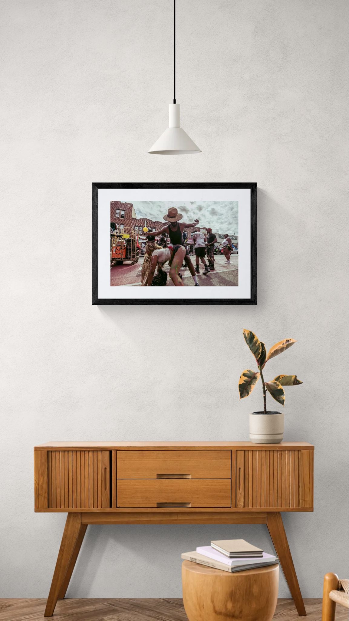 NYC J'Ouvert Straw Hat Dancer, Crown Heights framed in black above a beige sofa, sunlit yellow plaster wall — Good Beans NYC.
