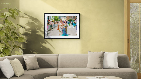 NYC Mermaid Parade Mermaids Posing, Surf Avenue framed in black on a gallery wall with a side-profile viewer in a dark coat — Good Beans NYC.