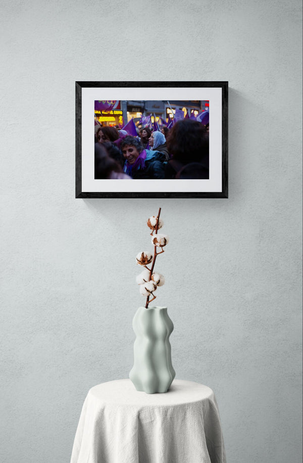 Istanbul Women's March Old Lady, Istiklal Avenue framed in black above a brown leather sectional, teal wall, gold pendant lamp — Good Beans NYC.