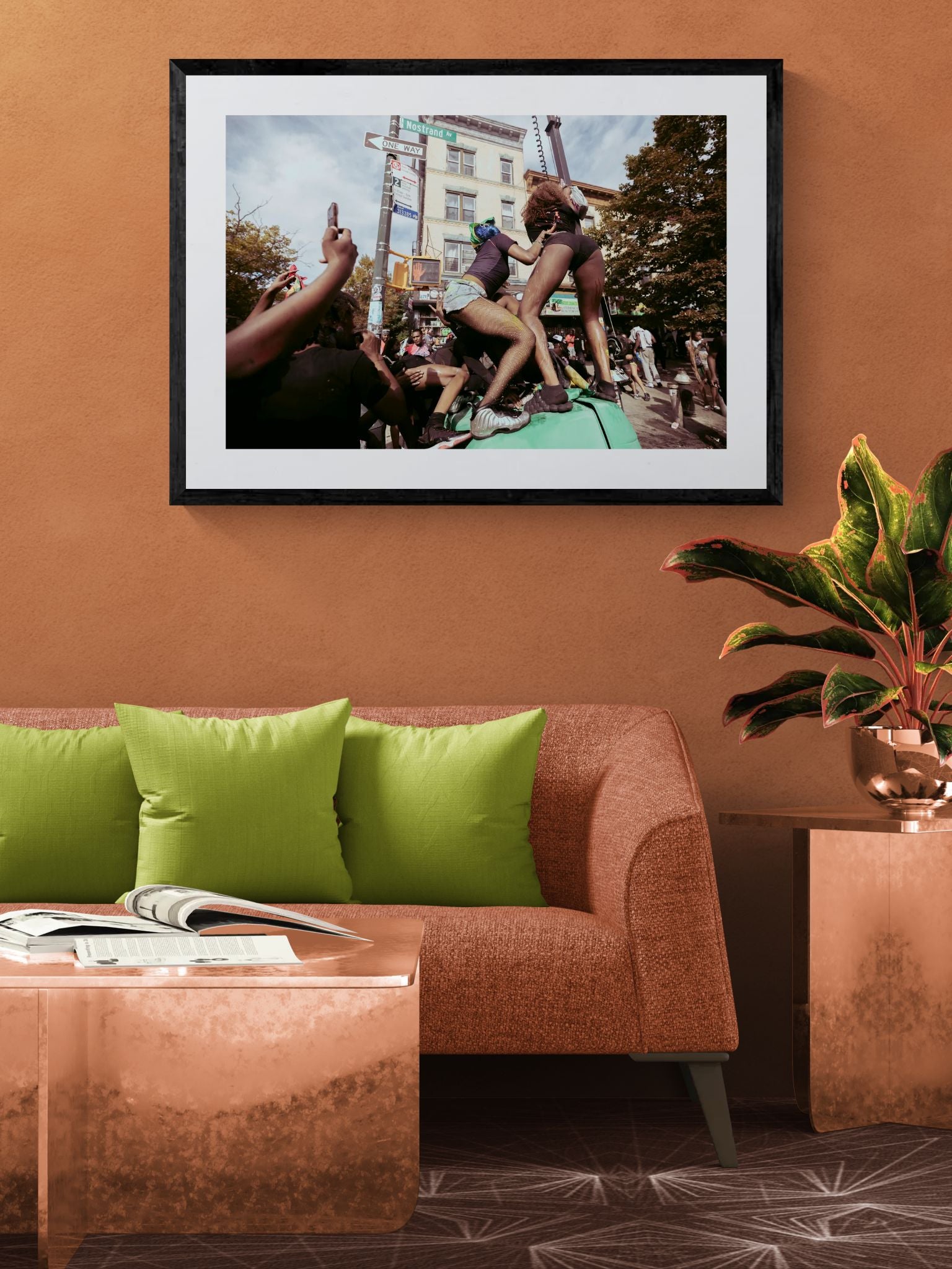 NYC J'Ouvert Twerking, Nostrand Avenue framed in black above a beige sofa, sunlit yellow plaster wall — Good Beans NYC.