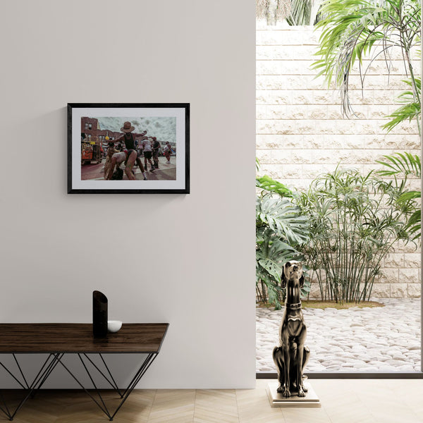 NYC J'Ouvert Straw Hat Dancer, Crown Heights framed in black above a terracotta velvet sofa, gray plaster wall — Good Beans NYC.