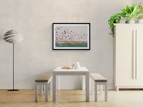 Barcelona from the Air, Barceloneta Beach by Karim Iliya framed in black on a gallery wall with a side-profile viewer in a dark coat — Good Beans NYC.