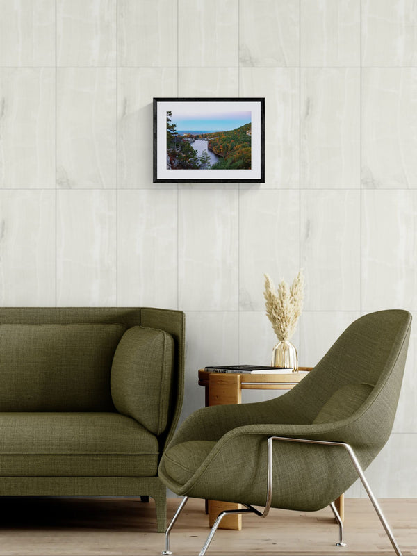 NY Mohonk Mountain House Fall, Hudson Valley framed in black on a gallery wall with a side-profile viewer in a dark coat — Good Beans NYC.