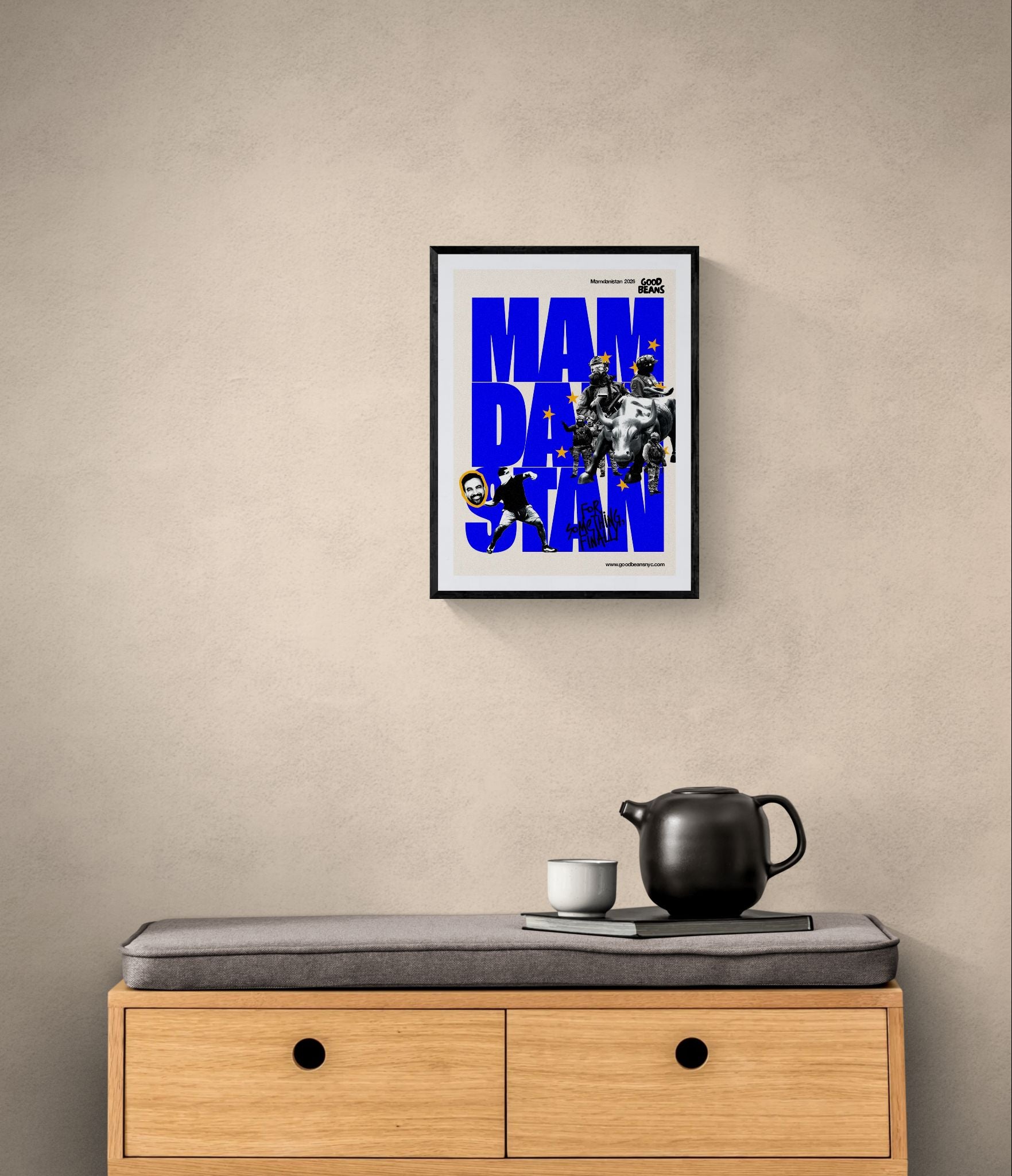 Mamdanistan Poster, Mayor Zohran Mamdani framed in black above a brown leather sectional, teal wall, gold pendant lamp — Good Beans NYC.
