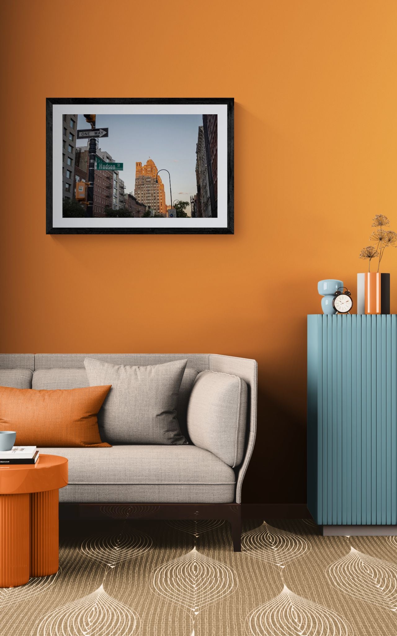 NYC Hudson Street Sunset, West Village framed in black above a beige sofa, sunlit yellow plaster wall — Good Beans NYC.