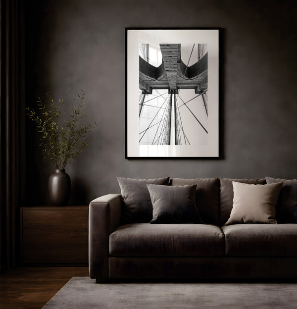 NYC Brooklyn Bridge from Below, Granite Tower framed in black above a terracotta velvet sofa, gray plaster wall — Good Beans NYC.