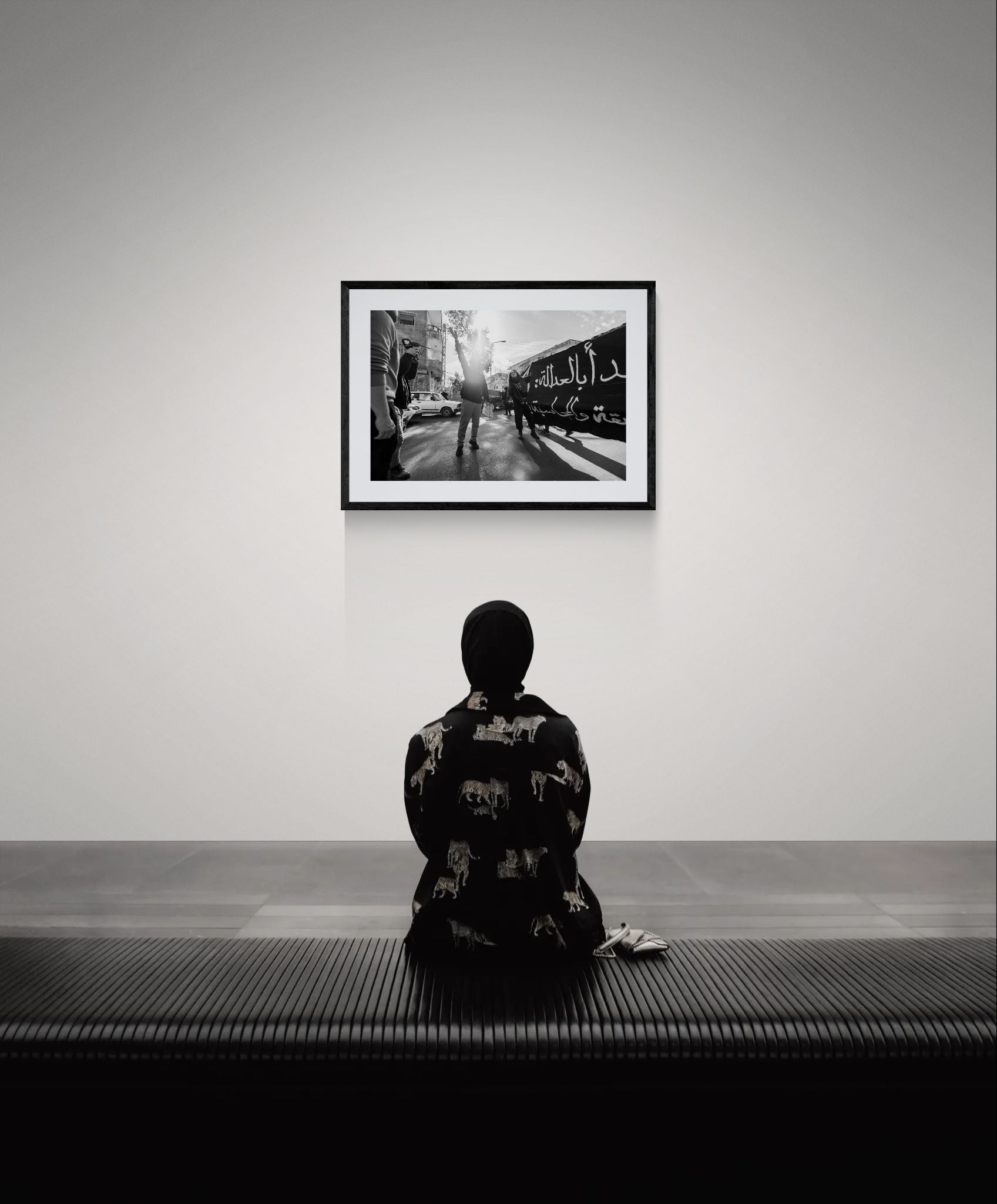 Damascus Raised Fist Protest, Syria framed in black above a terracotta velvet sofa, gray plaster wall — Good Beans NYC.